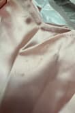 Arrived with a small pull in the satin fabric and stain spots all down the front! Also, I am a small in most clothes and a true size 4, but this is too tight at the waist sadly. - Sarah H.