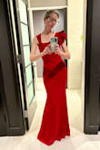 This is truly such a beautiful dress, the cut is so flattering, and the asymmetrical neckline and ruffle give it so much flair. Would be beautiful in any color, but it is an absolute showstopper in red. I do think it runs small. I originally ordered an XS, which is my usual size, and while I was just able to get it zipped, it felt uncomfortably tight. I exchanged for a small one and was super comfortable all evening. I'm 5'5'' and it grazed the floor with heels on. - Emily D.