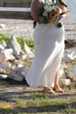 I'm a little thicker in the hips and have a larger booty, so this dress fits a little snug in that area. Unfortunately, the dress did rise, and because of the slit, this made the dress go up higher on my thigh than I would have liked. It was a windy day since we held the ceremony on the beach. I would recommend hemming it a few inches to avoid having to hold it closed like I did while walking down the aisle because of all the wind blowing it open. Other than that, this dress was perfect and served its purpose. I didn't want something too plain, and I feel like this dress did elevate the aesthetic of simple but elegant. Would strongly recommend wearing a slip dress underneath as this was super sheer and it hugs your body and can be a little unflattering if you have a mom tummy like myself. - Gladys B.