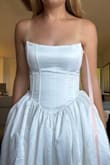 This dress is gorgeous. It's so flattering how you can tighten it with the corset back and it goes out at the hips. I also love that it has pockets. The top feels very secure as you can tighten it as needed. The train isn't too long which is nice. Just enough. There's also a little tulle underneath to give it shape. A very nice white satin and it's not too heavy. Will look amazing with a good steam. I can't wait to wear this for my wedding. - Emily S.