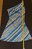 I bought this for a bachelorette trip in a size S. I'm shorter than the model, with wider hips (37"), a small bust (32/34A), and waist (26"). Based on the image, the model is wearing a size S, and it appears like the hem of the dress reaches just below/at her fingers. I didn't have another option, so I had to wear it, but this dress is ridiculously short. I'm not against short dresses, but based on the description and images, I expected it to be longer than what I got. Crotch height is not really the vibe this dress gives. I measured, and my fingertips are 5" past the hem. Note that there are no built-in shorts underneath, which I didn't expect but would have been nice considering the length. I had to wear it to dinner. I put a micro black skirt w shorts underneath to try to make it look like it was part of the dress. Also, there was no way I could size up to an M because the side that is off the shoulder was baggy on me, and I had to tape it up. This dress is basically a long shirt. - Cierra S.