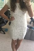 I believe the fit runs true to size. It definitely isn't as short as shown online. The sides under the arms need a little tailoring to fit perfectly. Its a comfortable material. The lace details are way more prominent in person. Its also not a bright white. Was going to wear it for my city-hall wedding but I don't like how my back looks in it. - Heather B.