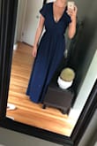 I sized down, as precious reviews suggested. Based on the sizing chart, I was a large- so I ordered a medium. I could've probably ordered a small. I will have to have his dress taken in a little bit in the waist. In my picture, I have a good couple inches of fabric from the waist tied back. The neckline does go very low and would likely need to have a snap added to help it stay closed. I used two way tape to send this picture to friends and it wasn't strong enough to hold the fabric closed. When I first took it out of the bag, the fabric seemed like it would be see through, but having the dress on I didn't think it was a problem. I am wearing 2-3 in wedges in the pic. - Stephanie C.