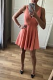 I had been eyeing this dress for a while, and after reading the reviews I ordered a size XS.

The fabric is polyester, so it's nice and stretchy. The skirt has a nice skater swirl.

Colour is exactly peachy.

Recommended! - DaniÃ«lle T.