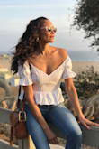 This top is for the "It Girls". It is so beautifully cut with a sweetheart neckline with cute ruffled, puffed sleeves. Looks equally as beautiful on the shoulder or off the shoulder for a little bit of a sexy look. The peplum fits right at waste and the length of it covers the top of your denim or skirt. Its smocked back makes it so comfortable to wear with or without a bra. Love it. Got a lot of compliments on it. - Karen M.