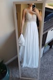 I adore the low back and plunging neckline on this gown! The beading is very intricate in a scalloped pattern over a mesh top with bra cups so it's not too risque. Unfortunately the cups are set a little high or are too small for me, but that's an easy fix the seamstress can handle when I get it hemmed! The length means it will even have a small train after hemming it that she can add a bustle feature to comfortably dance the night away (note I'm wearing heels in these pics so there is even more fabric for a train at my height than it appears in the photo). I love this dress way more than any gown I tried on at a bridal salon and it was a fraction of the cost! - Christine M.