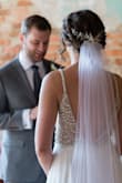 Absolutely love this dress, the only thing I had done to it was hemmed and took off the train. I wanted something with a more contemporary look while still maintaining that bridal elegance (and not looking like a prom dress). I love the scalloping detail that carries throughout the beaded bodice. There are 3 types of "beads" in the bodice; a very simple square cut rhinestone with silver metal outlining, an iridescent "pearl" , and iridescent sequins throughout. The cups are sewn in, but they are not noticeable when you are wearing the dress (at least for me since my skin tone is very similar in shade). The cups are a bit small, so I would take that into consideration for anyone with a C cup or more (for the size 6 I ordered); however, it looks easy enough to have a tailor put different sized cups in. The dress is long and has a slight train to it, so if you don't plan on wearing heels it might need to be hemmed. The fabric is very soft and has a great drape and flow to it and is very comfortable to wear. Literally all night wedding guests, vendors and servers compliment the dress and said it was one of the most wedding dresses they've ever seen. Best part was when I told them it was less than 300 dollars!! So glad I bought this beautiful dress, it was absolutely perfect!! Since I'm posting professional photos, I need to disclose my photographer was Amelya Jayne Photography in North Carolina. - Leah M.