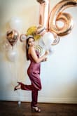 I bought this jumpsuit for my daughter to wear to her 16th birthday party. She is petite and I didn't want to have to have anything hemmed. Arrived quickly and it is BEAUTIFUL! It's 100% poly which means it steams well and it will also wash well. Not to mention its the most beautiful burgundy color....just perfect for her party and then to wear again to a Holiday party. She is a true size 0, with a booty and an XS fit her perfectly. - Kim A.