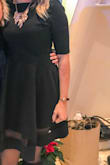 I bought this dress for my company Christmas party and as I am on the taller side, I'm always conscious because it is a work party, of my dress being too short. This dress was the perfect length and with the sheer panel, it added a touch of sexiness to an otherwise conservative (in my opinion) dress. I ordered a Large and it was a smidgen big in the waist area, but as I have slightly broader shoulders/more muscle in my arms, I was happy with the large for those areas. Overall, very happy with the dress! - Kathleen B.