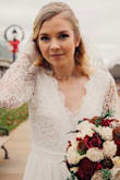I purchased this as my wedding dress. I had a very specific vision of what I wanted my dress to be and a very tight budget! I loved the lace sleeves and detail of this dress as well as the open back. I was nervous that the dress would end up not being dressy looking enough for a wedding so I added a chapel length veil. It worked perfectly! The dress runs long. It has three layers of fabric on the skirt. It is more of an off white color than a white. It ran big on me so I had it altered but it overall was worth it!! I highly recommend! I got TONS of compliments. - Melissa S.