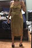 I really like this dress because it has potential and it is unique. I have olive skin, so the color looks good on me. It is too long for me, so I would definitely hem it above the knee per my style. Overall, it is a size too big. I am never a XS anywhere I buy clothes, so it's baffling to me how much extra material there is in the waist and the bust! Underneath the armpits gapes quite a bit. The fitted lining underneath fits perfectly, but the gold pleated layer looks like a bag hanging on me. There's no shape to this dress. Also, the slit edge of the dress arrived shredded and jagged because the material on the slit is not stitched, it's just cut, so any little bit of stretch is going to ruin it. I was pretty disappointed, but it's a final sale. I'm going to see what the tailor can do for me. - Stephanie S.