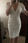 Like other girls on here I ordered this dress for my bridal shower. I wanted something sexy and classy that wasn't too old or too young for my age (27). The material is thick and tight, but not too tight! The right kind of tight that makes you feel secure and allows the white dress to not be see-through. I have a large chest, medium waist and very small hips so I was worried that I wouldn't be able to find my size or that it wouldn't look good on me. I chose Medium and it fits GREAT! It gives me a little bit of hip and the neck doesn't plunge too deep. I think the decolletage is tasteful and the cold shoulders add some fun! It's sexy and classy and still compliments the not too tiny waisted girls! Ps: it does wrinkle easily. - Kenna M.
