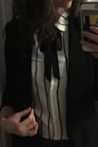 I really love this blouse! I wore it to work under a blazer and tucked into black jeans, and I felt really cute and put together. I didnt know how the little black bow would look, but I love it! I could definitely wear this out too. I am usually a medium in shirts, but bought a small based on other reviews. I am glad I did. It was still a little bit loose. The sleeves are puffier than the picture makes it seem, so wearing it under a blazer or sweater is how I feel it looks best. The material is thin/sheer (which I actually like), so I did have to wear a tank top underneath. - Lauren S.