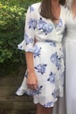 The material is light and nice for spring/summer occasions, especially with the pretty flower print! The colors are accurately portrayed in the photo! I am not the best with tying wrap dresses and am small-chested so I wrapped and tied it pretty tight to ensure that it stayed. The v-neck comes down low so I wore a bandeau with it which worked well. - Carly G.