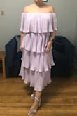 I purchased this dress for a friend's wedding. I'm a US size 12 and ordered the XL. Because the waist band is elastic, I will exchange for a smaller size. I was worried that the tiered ruffles would be unflattering on my hourglass figure; however, after trying-on I think it looks fine. This dress is so fun. I can't wait to dance the night away in it. - MEAGAN C.