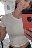 I'm going to exchange mine for a medium and in black. I'm wearing a nude bra in the pic and you can see it, the tag on the shirt, everything, BUT the material feels great. Also of note, the seam of the shoulders is set in a little bit. My finger is where the edge of my shoulder is. - Meredith E.