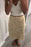I'm always nervous with these kind of skirts that it's going to show a bulge in the stomach area but this one doesn't. It's great quality and I ordered a small and still have some room. It's a great fit and the yellow makes my tan pop a little. I love the color. - Renee B.