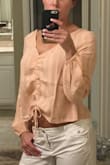 This fits great. If you have a larger bust it will pull at your shoulders and feels weird. It's shorter than I thought it would be. I don't really want my belly button to show at my age so will be returning. - Shelly K.