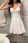 I bought this dress in a size S (followed the size charts!) to wear under my cap and gown for commencement/graduation! It is a BEAUTIFUL dress, and I love the lace back of it! The material is very breathable and comfortable, a bit stretchy and honestly I probably could've sized down to an XS and still fit. I was concerned about the length and if it would squeeze me weird when sitting down. My breasts literally grow a cup in size whenever I'm on my period, so at least with the small I know I'll fit no matter what time of the month haha.

If you are graduating, looking for a bachelorette dress, or just looking for a white mini dress in general, I cannot recommend this item enough! Seriously, just buy it! - Jenny J.
