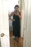 It's a beautiful dress! It's not super formfitting but doesn't feel like a sack either. It falls nicely on the body and isn't too loose on the waist or hip area. The strap is adjustable as well. It would look great with a patterned small belt also! The slit is the perfect touch and the fabric is sooo soft and not see-through either which was my main concern. - Mimi H.