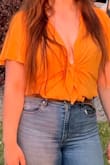 I love this bodysuit! The color is an orangish yellow, similar to the picture. The fit was okay overall, but my only complaint is that the clasp on the front of the blouse pulls open frequently. I didn't mind wearing it open, but it does show a lot of cleavage and others may not be as keen on that fit. - Kiahra K.