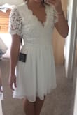 This dress is beautifully feminine and innocent. I bought it for my bridal shower. I normally don't wear low cut things, but this felt comfortable to me. I felt it showed some skin while still being covered. The top is structured and bottom is flowy. Fit perfectly! - BRITTANY C.