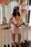 I wore this dress at 33 weeks pregnant for my baby shower in a size medium. It was a little tight, but it still worked great for me. I am usually 5'2" and 130 lbs, at 33 weekend about 150 lbs. I received so many compliments on the dress. Comfy and stretchy. - Marissa G.