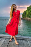 I have this in black and red. The old fit ran small, but they fixed that this time around. It's true to size now. The waistband is an exact fit so maybe not so nice with a food baby. It's amazing dress though!! It's super flattering and conservative while still being super cute. :)
The photo is the old fit where I'm wearing a medium. Obvi a little filtered too. It's not that bright of a red. - Marissa S.