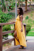 I bought this dress to take on a vacation in Cabo, it was perfect for transition from brunch to beach and even a fun summer night dinner. I even wore it for an impromptu photo shoot once I returned home. The slit is a pretty high but not crazy. I didn't have to get anything adjusted. The fabric wrinkles easily, so plan on ironing/ steaming once you take it out of your luggage. The back is also low cut so only nipple pasties or bra cups. The halter design gives nice support though so bra cups were okay for me. Highly recommend! - Kerry-Ann M.