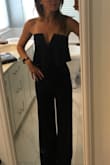 I LOVE this jumpsuit. I cannot believe that it actually fits. I have zero boobs and didn't think I could possibly hold up a strapless anything. This has boning in the top that helps keep it in place as well as some sticky tap around the top. It is too long so I am having it taken up, but that's no big deal. I ordered the navy to wear to a wedding. - Ashley S.