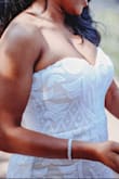 I loved loved loved my dress. I wore it when I got eloped in Savannah and it fit me like a dream. I got a strapless push up bra because I had like no cleavage if I went completely bra less but it prob would have been fine. ESP if you want a more conservative look. It hugged my curves just right! I wore 3 in heel and chose not to have it hemmed so I could have some length while I took pics but If I had had to walk down an aisle I def would have needed some inches off. - Signy J.
