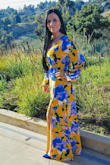 I absolutely love the color yellow! I purchased this dress to wear to my cousin's wedding. Best decision. This long gown is absolutely gorgeous. I love the artist, Vincent Van Gogh, and the dress called me because it reminded me of something he would paint with yellow. Very hippie chic... so my style. The yellow is bright like sunshine and the blue flowers are a beautiful royal bold blue with a hint of green and peach accents for the leaves. It is made of thicker chiffon-type material with a silk lining. Great quality. The slit on the left leg leg gives the flowy bottom a very sexy flair. I wore some royal blue fringe tassel earrings and a yellow statement ring. The dress is so amazing simple accessories are best. I love the hippie-glam look so I just wore my hair straight. I got so many compliments, I was very comfortable, but most importantly I felt gorgeous. I am 5'2" and I purchased a medium. The only thing I had to do was fix the hem about 1 foot. That allowed me to have a little drag with my heels. I can't wait to wear it again! Thank you LuLus! - Elizabeth R.