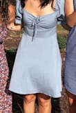 This dress is adorable. It is as pictured on the model. I went with a small (I am 5'3, and range between 120-125 lb) but it is a little big in the rib cage area. If you are around that size I'd go for the x-small. It is long enough in the back that it is comfortable and not too short. Good quality fabric. I love the color-gives princess vibes. - Kara K.
