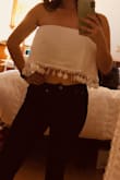 Wore it with dark jeans and pointy brown booties for a country concert. It is not sheer or see through, which is usually an issue with white fabrics. Stayed up the whole night with a strapless bra. Super cute! The fabric was sturdy and much better quality than I expected. Worried if the delicate tassels can survive the wash... I may dry clean just to be safe. - Irene F.