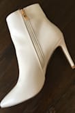 I really wanted a pair of these white boots as they are on trend but didn't want to spend a fortune on a trendy item. I got these with the 15% off. I was nervous because I am 5' 0" and 105lbs and have scrawny ankles so I was afraid they would be too boxy or loose fitting around the ankle especially since the picture doesn't show how they fit around the top of the ankle. Thought they might be trying to hide the fact that they aren't very flattering. Well....that isn't the case at all. I am very pleased with them! They fit perfectly and are comfortable. I highly recommend. The gold zipper pull is attractive as well. - Pamela S.