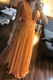 This dress is so flattering on and the orange color is so fun! I ordered the XS (I usually wear a small) and it is a little tight on my rib cage because of the criss-cross style, however I was able to make do! It's very loose fitting in the stomach area. In the picture I attached, I'm barefoot and 5'5". If I wasn't planning on wearing heels, it would definitely need hemmed. The material is lightweight and perfect for a summer event! I can't wait to finally wear it. - Amber C.