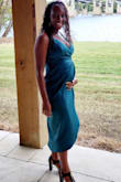 I was 14 weeks pregnant in this photo. I didn't want to buy a maternity dress for the wedding because they either A.) make me feel frumpy and bleh © or B.) have flowers! Lol. This faux wrap dress fit perfectly over my bump and I felt cute and sexy. It was also VERY easy to use the bathroom (which of course I had to do 7,000 times). My husband liked it as well, so we know it's a keeper. My pregnancy boobs are massive (for me) and on display, so if you don't like a lot of cleavage, this may not be for you. I ordered a size up to fit my changing body, it fit perfectly. - Shavavian A.