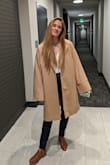 Oversized with long sleeves is an understatement. I am a medium in all of Lulu's but after reading the reviews for this coat I sized down to a small. Still had plenty of shoulder room, even with wearing a suit underneath. I realistically could have ordered an XS and been fine. Warm and received lots of compliments. It's a wardrobe MUST. - Morgan V.