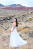 This dress is pretty. I ordered it for my elopement. I am short only 4' 11'' and when I tried on the dress it was extremely long and heavy! I had to get it altered which was fine. She took a lot of fabric off and was able to give it a nice train. The top part fits well, I ordered a size 2. However, while we were taking pictures I started to realize how heavy the dress was. I was constantly pulling it up and it got very uncomfortable. The back is a V shape and it doesn't feel as snug as I would have hoped. Overall I rate this dress a 3, it was ok. - Tianah S.