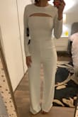 This Jumpsuit fits like a glove - I was worried that the legs would be way too small when ordering a size S. I purchased for a black and white gala - I am not sure if I am keeping yet, waiting for some black jumpsuits to come in lol! The material is very stretchy- I would most likely wear spanx in these since white tends to show everything lol. Only downside is that you may need assistance to get in and out of this! - Jamie F.