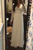 I purchased this in an XS as a potential wedding dress and it runs true to size. I really loved the sleeves and open back. I didn't find the style in the front flattering so I returned it. - Angell