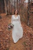 This dress was all I ever wanted for our outdoor winter wedding. I am still getting compliments on it two months later- it's a beautiful material, unique style, and so flattering! I bought a Medium, and it fit perfectly around the waist and bust. However, I did have alterations for tightening the sleeves, tightening where the lace connects to the skirt on the back, and taking off some length. It was totally worth it, as I paid less for this dress+alterations than I would have for another dress alone anywhere else. 
If you are looking for a wedding dress for a small wedding, outdoor wedding, elopement, or literally any event, this is your dress.
Tips: must get a cup-only sticky bra if you plan on wearing one, hair looks good up or down with this dress, and your entire back will be exposed.
Below are photos taken by my wedding photographer, Christina Cerda Photography, that I've cropped to show the dress. - Bethany P.