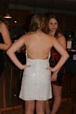Bought this dress for my 15 yr old for her winter formal at school. She's very petite and usually the XS's fit her perfectly. This dress was no exception. It wasn't too tight on her and even though I needed to alter the back straps by bringing them together with white thread (see photo) and was told by her friends that it looked like it was supposed to be that way. - it didn't ruin the look of the dress at all and it actually made it fit her even better.  She got tons of compliments and she looked gorgeous. The sequins in the dress are silver (although pictures online they look white) but the dress was still very pretty. The strap is one long piece of elastic that runs throughout the whole dress (from one shoulder down and across back and up the other side) so it isn't adjustable unless you can sew (or do what I did). She said she had absolutely no problems with it being uncomfortable. - Nicole P.
