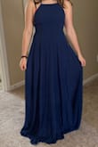 The dress fits true to size. If you're a bit bigger than the size chart, you'll be fine because the material is a bit stretchy and isn't uncomfortable with it like that. I absolutely love how the straps are adjustable and the high neck makes my shoulders seem less broad. I got it in the dark blue color and it makes me look a little tanner than I really am. (I'm not complaining!) You should definitely get this dress, especially if you're looking for a prom dress! I have a bra on in this picture only because I was just trying it on, but I don't need one with this dress (so one less thing to worry about!). - Nicolle S.
