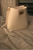 I bought this as a carry on bag for the airplane hoping it would fit my iPad, large reading book, clutch with all the essentials in it, and chargers. Everything fit perfectly, plus maybe a few snacks. The width was just perfect to slip an iPad in without much wiggle room and the bag is not oversized, which I love!! - Angel R.