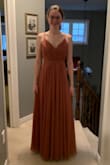 It arrived in 9 business days. Ordered this to wear as a bridesmaid dress. The wedding will be in September. It has a good weight and the adjustable straps are perfect. The dress is the perfect length with heels. - Emily D.