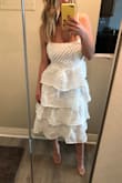 I bought this for my now postponed wedding shower (thanks COVID-19). I am still hopeful I get to wear it. It's PERFECT! i was worried it might make me look "big", but it moves so beautifully, is the perfect length, and looks amazing on. The zipper does get stuck on the little poms though, I got it to zip down about halfway, which makes it very hard to get on! - Paige M.