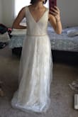 This dress has a beautiful color and a lacey texture! It is not "too white", which is a huge plus for me. It also has a gorgeous built-in pearl belt. I could easily wear it with a bra. It is extremely comfortable and easy to move around. The V neck is perfect and secure. It was large for me so I would order an XS for sure. The skirt is slightly fluffy and has a veil overlay. I felt that it could have been prettier without the veil. The material is very high quality for the price! I eventually decided that form fitting dresses complimented my body type more. So I went with another Lulus dress! - Ayca C.