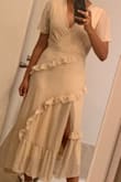 I bought this dress for my rehearsal dinner, and I cannot wait to wear it! It's so comfortable and form fitting without being too revealing. The slit on the front is so cute! I have broad shoulders so I wrestled between getting a small or a medium, but I'm happy I went with the small. The cut outs on the shoulders allowed for more room there without gaping, and because of that the rest of the dress fit me perfectly. Had I gone with a medium for the shoulders, I think the waist wouldn't have fit as well. It is definitely more cream than white as it kind of shows in the picture online, so know that going into it! It goes midway down my calf! Gorgeous dress overall! - Claudia A.