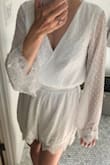 This romper fits loose and is super comfortable to wear. It has a heavy lining with see-through sleeves, which show off the Swiss dot pattern nicely. The sleeves are long on me personally and extend to my knuckles. The bottom on this romper is the perfect length, not too short or long. I plan on wearing it the morning of my wedding and possibly my shower as well. It's really versatile and would work great for any bridal event! - Amy S.